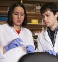 Tufts University assistant professor Bree Aldridge (left) and research technician Owen Bennion (right) examine a microfluidic device used to study how individual bacteria respond to antibiotics.